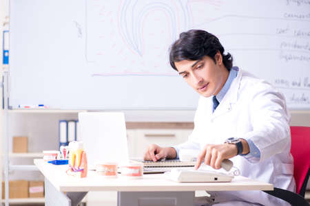Young handsome dentist in front of the whiteboardの写真素材