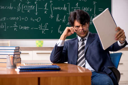Young male math teacher in classroom
