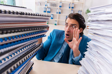 Young handsome businessman unhappy with excessive work