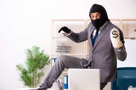 Male gangster stealing information from the office