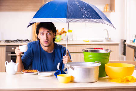 Young man in water leakage from the neighbors conceptの写真素材