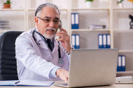 Aged male doctor working in the clinicの写真素材