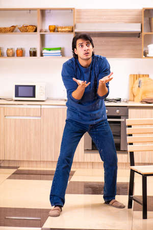 Young man in water leakage from the neighbors conceptの写真素材