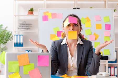 Young female employee in conflicting priorities conceptの写真素材