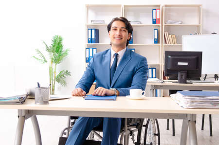 Male employee in wheelchair working at the officeの写真素材