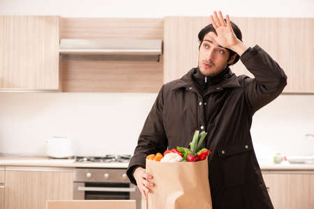 Young handsome man with vegetables in the kitchen