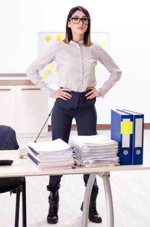 Young female employee doing exercises at workplaceの写真素材