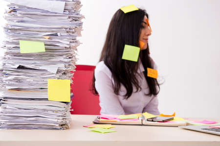 Young female employee in conflicting priorities concept