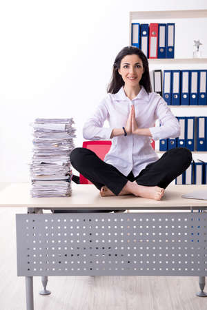 Young female employee doing exercises in the officeの写真素材