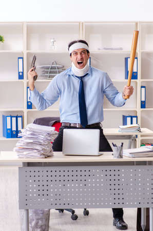 Young injured male employee working in the officeの写真素材