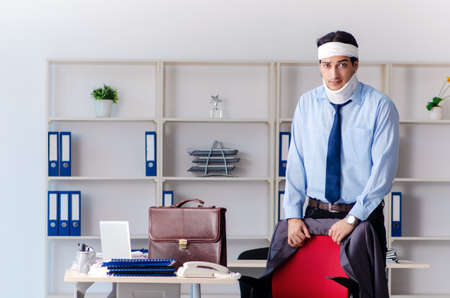 Young injured male employee working in the officeの写真素材
