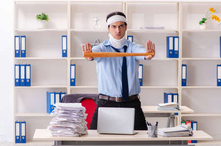 Young injured male employee working in the officeの写真素材
