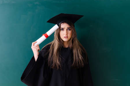 Female graduate student in front of green boardの写真素材