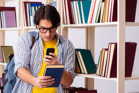 Male student preparing for exams at libraryの写真素材
