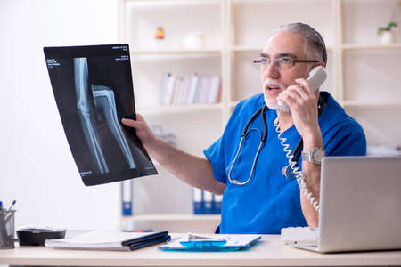 White bearded old doctor radiologist working in clinicの写真素材