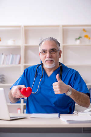 White bearded old doctor working in clinicの写真素材