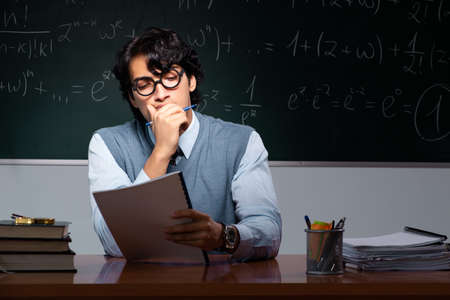 Young math teacher in front of chalkboardの写真素材
