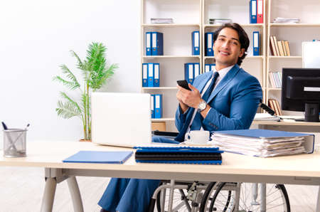 Male employee in wheelchair working at the officeの写真素材