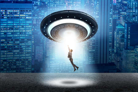 Flying saucer abducting young businessmanの写真素材