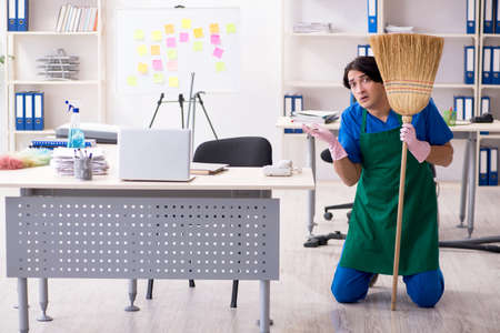 Male handsome professional cleaner working in the office