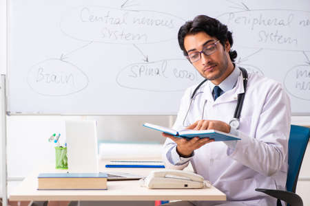 Young male doctor neurologist in front of whiteboardの写真素材