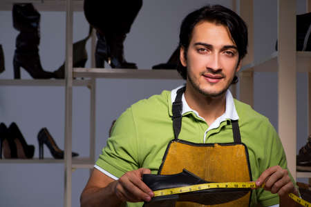 Young shoemaker in workshop at night