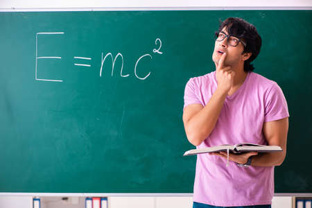Young male physic standing in front of the green board