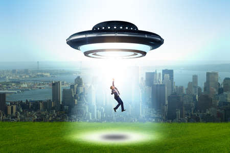 Flying saucer abducting young businessmanの写真素材