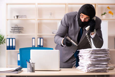 Male gangster stealing information from the officeの写真素材