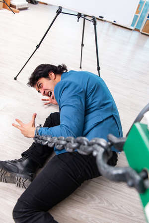 Chained male employee unhappy with excessive work