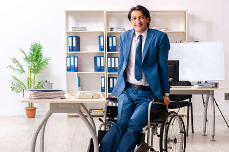 Male employee in wheelchair working at the officeの写真素材