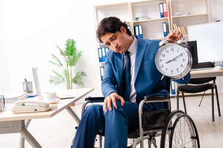 Male employee in wheelchair working at the officeの写真素材
