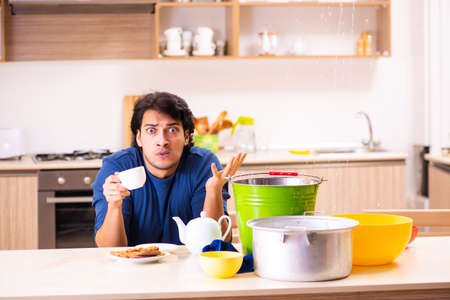 Young man in water leakage from the neighbors conceptの写真素材