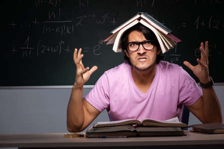 Young male student sitting in classroomの写真素材