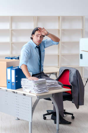 Young man employee with boxes in the officeの写真素材