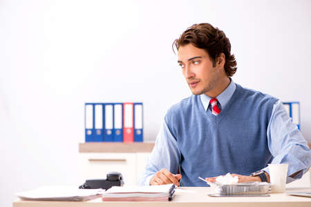 Young handsome employee working in the officeの写真素材