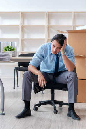 Young man employee with boxes in the officeの写真素材