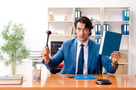 Young handsome judge sitting in courtroomの写真素材