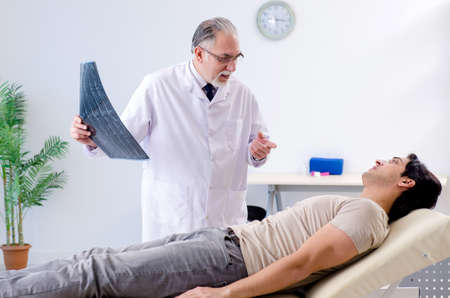 Young man visiting old male doctor radiologist