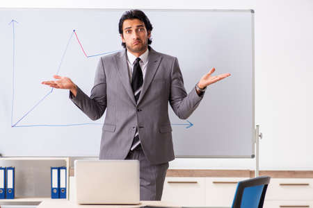 Young handsome businessman in front of whiteboardの写真素材