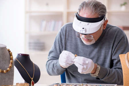 White bearded old jeweler at workshopの写真素材