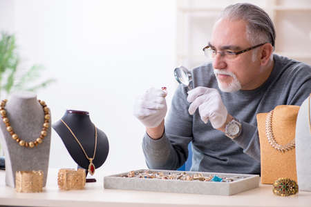 White bearded old jeweler at workshopの写真素材
