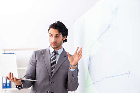 Young handsome businessman in front of whiteboardの写真素材