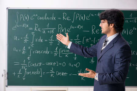 Young male math teacher in classroom