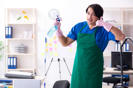 Male handsome professional cleaner working in the officeの写真素材
