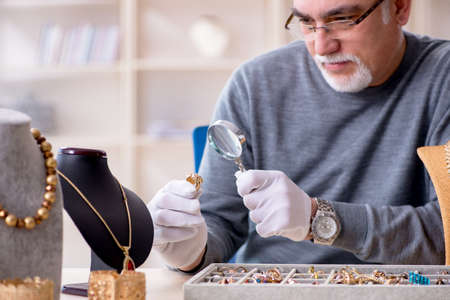 White bearded old jeweler at workshopの写真素材