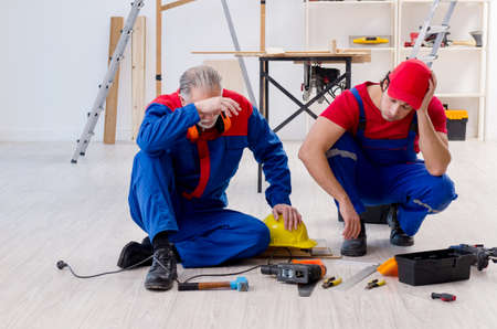Two professional contractors laying flooring at homeの写真素材