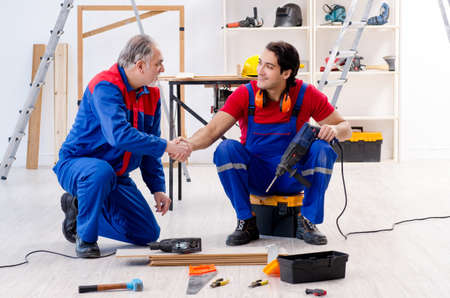 Two professional contractors laying flooring at home