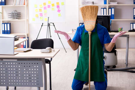 Male handsome professional cleaner working in the office