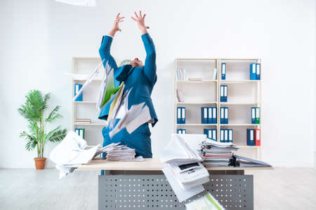 Young male employee unhappy with excessive workの写真素材